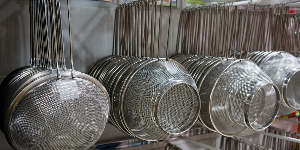 Strainers hanging on the wall.