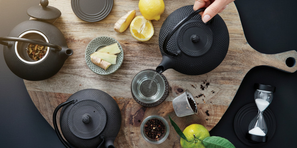 Gusseiserne Teekannen mit Teebechern